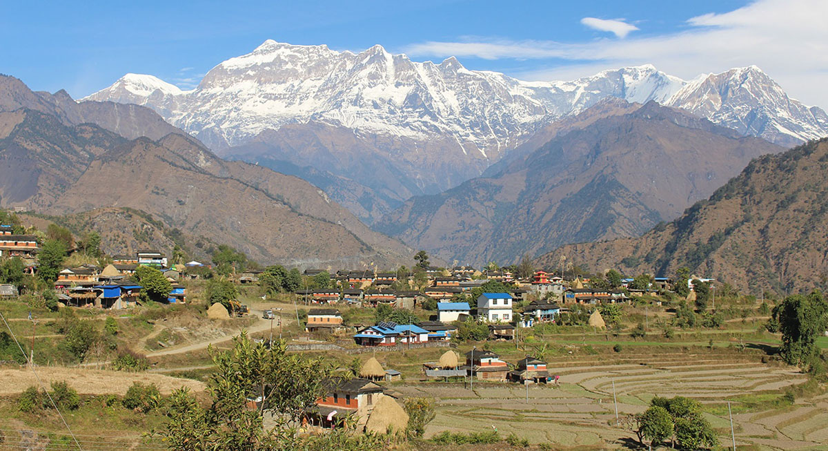 म्याग्दीकाे ताकम गाउँ र पृष्ठभूमिमा देखिएको गुर्जा हिमाल